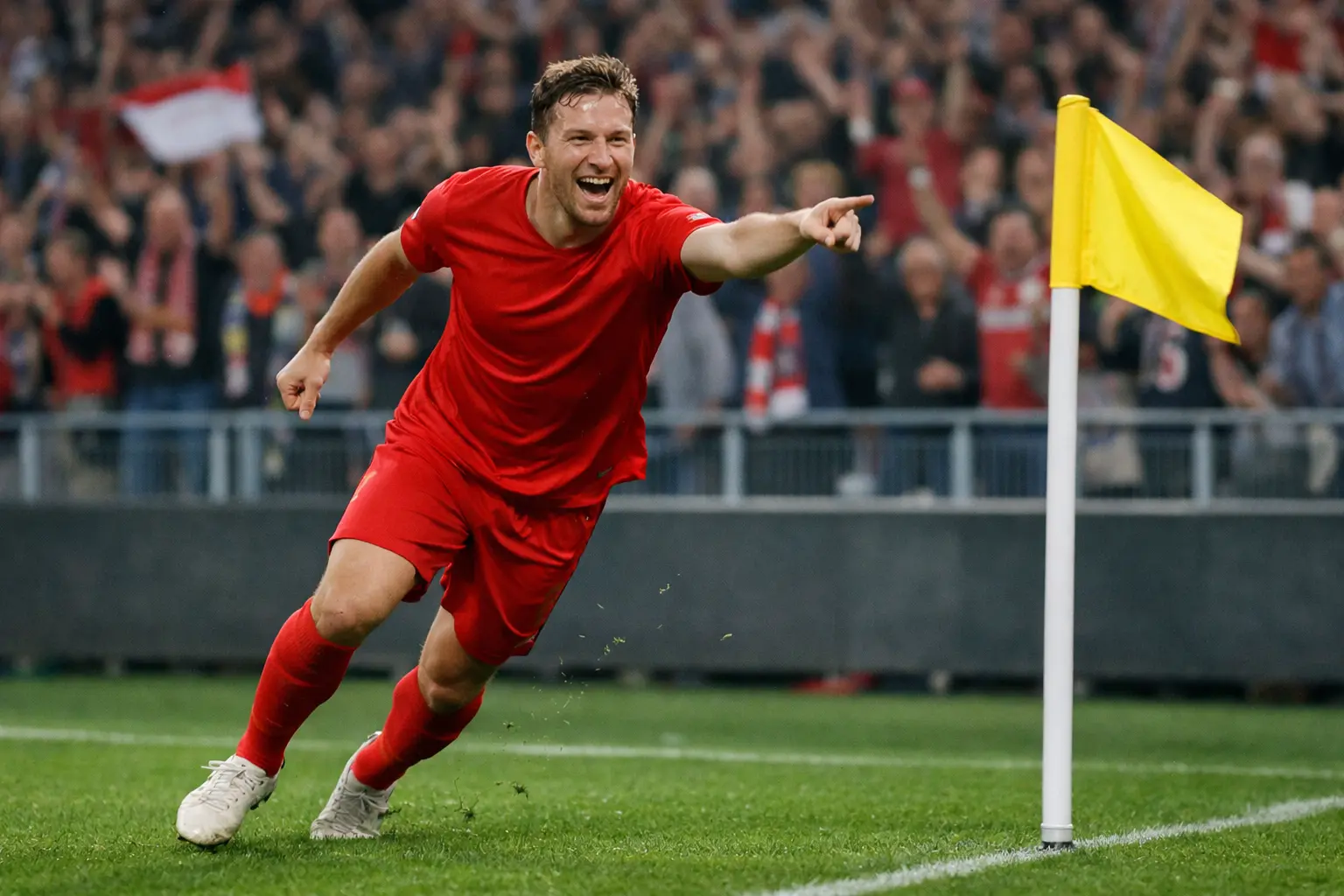 Fußballspieler jubelt nach einem Tor vor der Fankurve